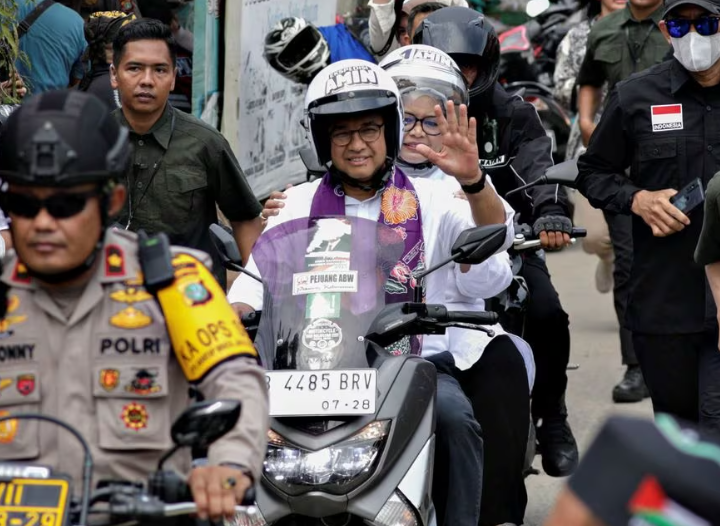 Anies Baswedan mengendarai sepeda motor bersama istrinya Fery Farhati sebelum berkampanye di Jakarta, Indonesia, 28 November 2023. REUTERS/Ajeng Dinar Ulfiana Memperoleh Hak Lisensi