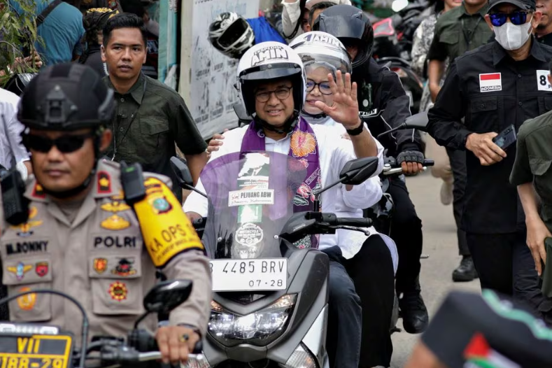 Anies Baswedan mengendarai sepeda motor bersama istrinya Fery Farhati sebelum berkampanye di Jakarta, Indonesia, 28 November 2023. REUTERS/Ajeng Dinar Ulfiana Memperoleh Hak Lisensi