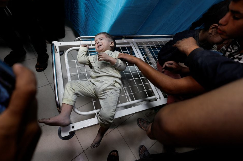 Seorang anak Palestina yang terluka dalam serangan Israel menunggu untuk menerima perawatan di rumah sakit Nasser di Khan Younis di selatan Jalur Gaza 12 November 2023. REUTERS/Mohammed Salem Memperoleh Hak Lisensi