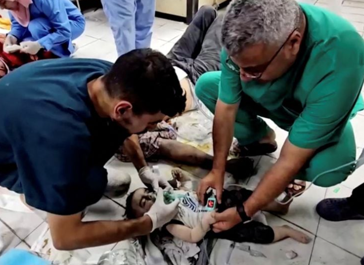Pekerja medis mencoba menyelamatkan bayi Palestina Mosab Sobieh, yang berusia kurang dari satu tahun dan terluka akibat serangan Israel di rumah mereka, di Rumah Sakit Indonesia yang kehabisan bahan bakar dan listrik, di Jalur Gaza utara , dalam gambar diam ini diambil dari video yang diperoleh Reuters, 12 November 2023. REUTERS/Anas al-Shareef Memperoleh Hak Lisensi