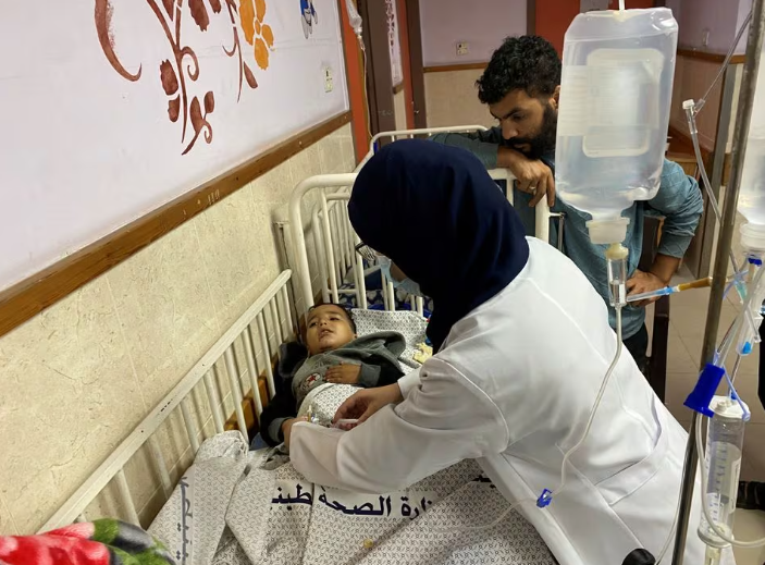 Bocah Palestina Ahmad Shabat, 4, yang menjadi sasaran dua serangan udara Israel, menjadi yatim piatu pada serangan pertama yang menewaskan orang tuanya, dan kehilangan 2 anggota tubuh bagian bawahnya pada serangan kedua, menerima perawatan medis, di Shuhada al- Rumah Sakit Aqsa di Jalur Gaza tengah 14 November 2023. REUTERS/Doaa... Dapatkan Hak Lisensi