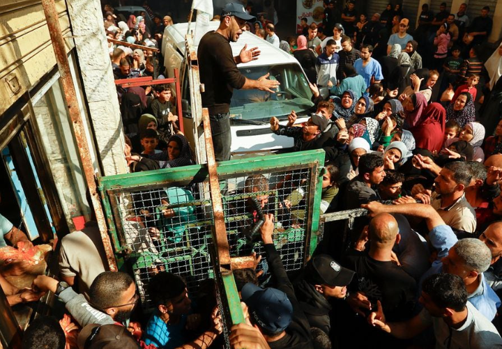 Warga Palestina mengantri saat menunggu pembelian roti dari toko roti, di tengah kekurangan pasokan makanan dan bahan bakar, seiring berlanjutnya konflik antara Israel dan kelompok Islam Palestina Hamas, di Khan Younis di selatan Jalur Gaza 17 November 2023. REUTERS/Ibraheem Abu Mustafa Memperoleh Hak Lisensi