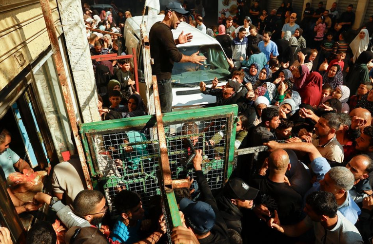Warga Palestina mengantri saat menunggu pembelian roti dari toko roti, di tengah kekurangan pasokan makanan dan bahan bakar, seiring berlanjutnya konflik antara Israel dan kelompok Islam Palestina Hamas, di Khan Younis di selatan Jalur Gaza 17 November 2023. REUTERS/Ibraheem Abu Mustafa Memperoleh Hak Lisensi