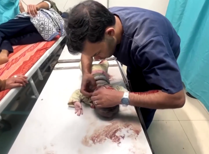 Seorang tenaga medis sedang membantu anak yang terkena serangan. Reuters.