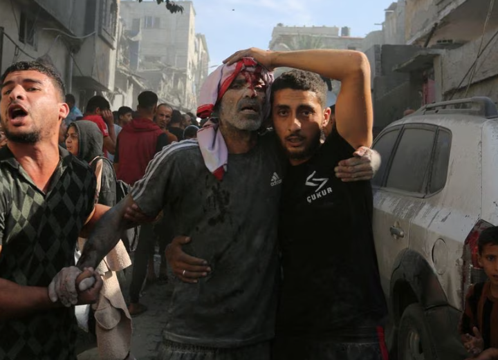 Seorang warga Palestina yang terluka dibantu di lokasi serangan Israel terhadap sebuah rumah di Rafah di Jalur Gaza selatan, 30 Oktober. REUTERS/Stringer
