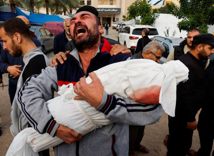 Seorang pria Palestina bereaksi saat membawa jenazah keponakannya Hanan Kaloob, yang tewas dalam serangan Israel, di rumah sakit Nasser di Khan Younis di selatan Jalur Gaza 22 November 2023. REUTERS/Mohammed Salem/File Foto Memperoleh Hak Lisensi