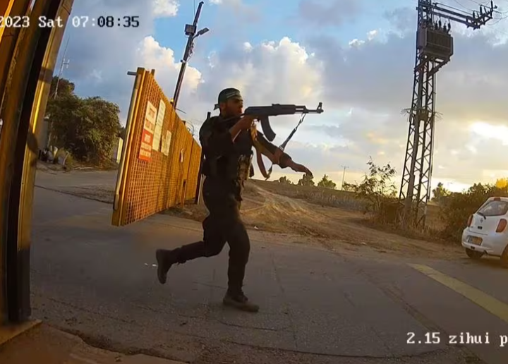 Orang-orang bersenjata berlari sambil memegang senjata selama serangan Hamas pada 7 Oktober, dalam tangkapan layar ini dari rekaman yang diambil oleh kamera pengintai di Kibbutz Alumim, Israel, dan dirilis pada 20 November 2023. South First Responders/Handout via REUTERS Acquire Hak Lisensi