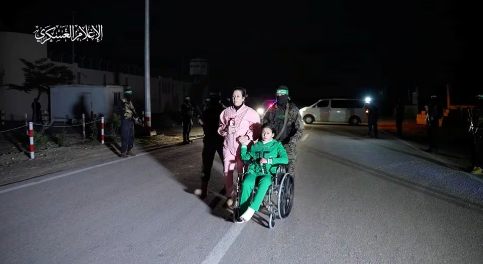 Para sandera yang diculik oleh orang-orang bersenjata Hamas selama serangan 7 Oktober di Israel, diserahkan oleh militan Hamas kepada anggota Komite Palang Merah Internasional, sebagai bagian dari kesepakatan pertukaran sandera-tahanan antara Hamas dan Israel di tengah gencatan senjata sementara, di lokasi yang tidak diketahui di Jalur Gaza, dalam tangkapan layar ini diambil dari video yang dirilis 27 November 2023. Militer Hamas... Memperoleh Hak Lisensi.