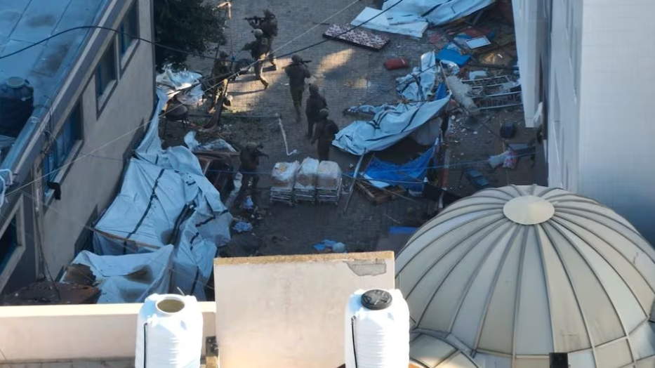 Tentara Israel berjalan di kompleks rumah sakit Al Shifa, di tengah operasi darat mereka melawan kelompok Islam Palestina Hamas, selama apa yang mereka katakan sebagai pengiriman bantuan kemanusiaan ke fasilitas di Kota Gaza, dalam gambar diam dari video selebaran yang diperoleh 15 November 2023. Pasukan Pertahanan Israel/Handout melalui REUTERS Memperoleh Hak Lisensi