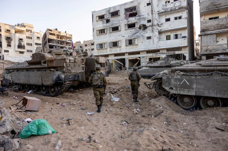 Tentara Israel berjalan melewati reruntuhan, di tengah invasi darat yang sedang berlangsung terhadap kelompok Islam Palestina Hamas di Jalur Gaza utara, 8 November 2023. REUTERS/Ronen Zvulun. Memperoleh Hak Lisensi
