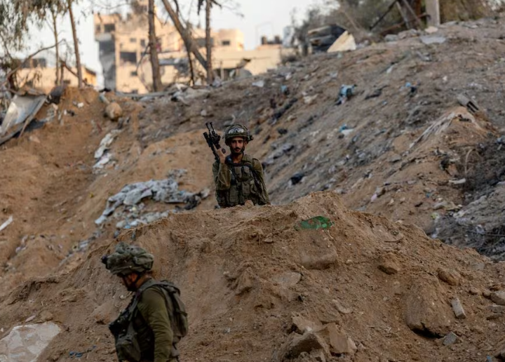 Tentara Israel berjalan melewati reruntuhan, di tengah invasi darat yang sedang berlangsung terhadap kelompok Islam Palestina Hamas di Jalur Gaza utara, 8 November 2023. REUTERS/Ronen Zvulun. Memperoleh Hak Lisensi