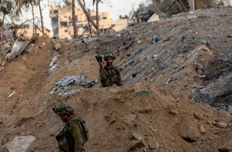 Tentara Israel berjalan melewati reruntuhan, di tengah invasi darat yang sedang berlangsung terhadap kelompok Islam Palestina Hamas di Jalur Gaza utara, 8 November 2023. REUTERS/Ronen Zvulun. Memperoleh Hak Lisensi