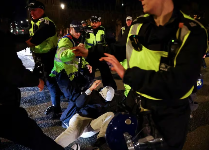 Petugas polisi menahan seorang pengunjuk rasa pada hari demonstrasi solidaritas dengan warga Palestina di Gaza, di tengah konflik yang sedang berlangsung antara Israel dan kelompok Islam Palestina Hamas, di London, Inggris, 11 November 2023. REUTERS/ Hannah McKay Memperoleh Hak Lisensi