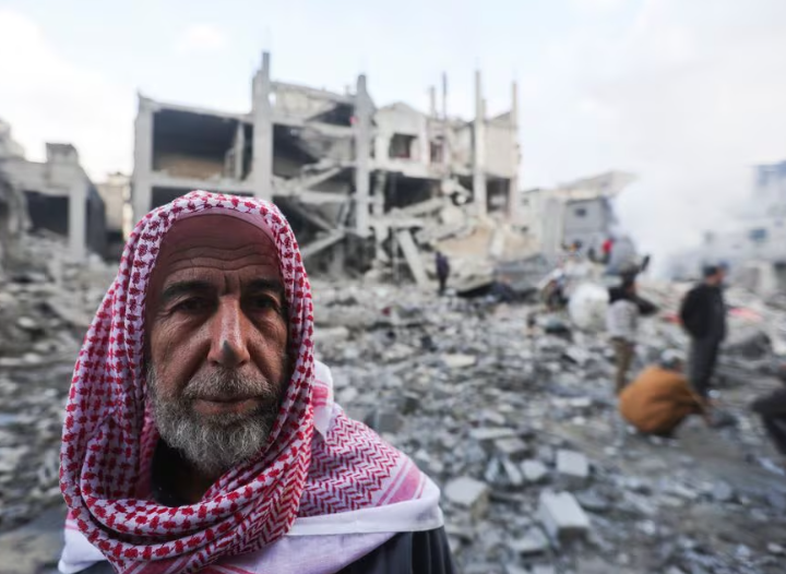 Seorang pria Palestina melihat lokasi serangan Israel terhadap rumah-rumah di Khan Younis, di selatan Jalur Gaza 14 Desember 2023. REUTERS/Ibraheem Abu Mustafa