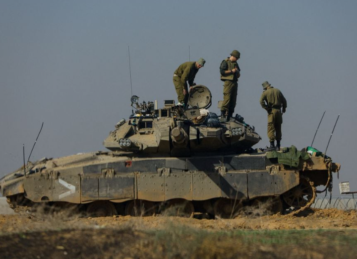 Tentara Israel bekerja di sebuah tank di dekat perbatasan dengan Gaza, di tengah konflik yang sedang berlangsung antara Israel dan kelompok Islam Palestina Hamas, terlihat dari Israel selatan, 3 Desember 2023. Gambar diambil melalui jendela. REUTERS/Alexander Ermochenko Memperoleh Hak Lisensi