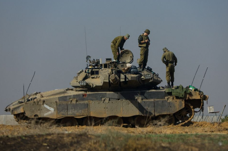 Tentara Israel bekerja di sebuah tank di dekat perbatasan dengan Gaza, di tengah konflik yang sedang berlangsung antara Israel dan kelompok Islam Palestina Hamas, terlihat dari Israel selatan, 3 Desember 2023. Gambar diambil melalui jendela. REUTERS/Alexander Ermochenko Memperoleh Hak Lisensi